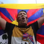 Un altro protestante che alza la bandiera del Tibet