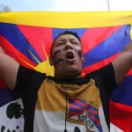 Un altro protestante che alza la bandiera del Tibet Un altro protestante che alza la bandiera del Tibet