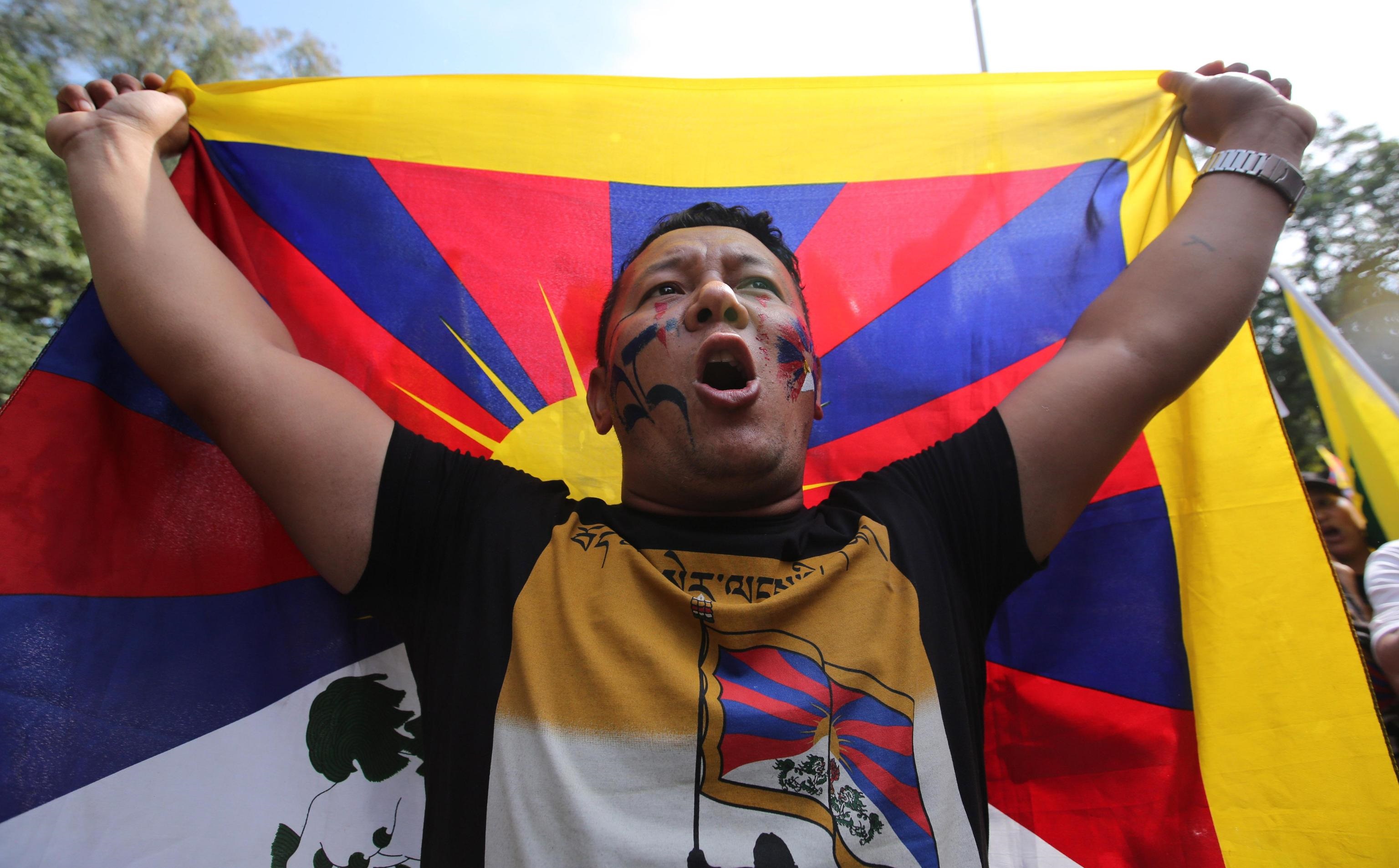 Un altro protestante che alza la bandiera del Tibet Un altro protestante che alza la bandiera del Tibet