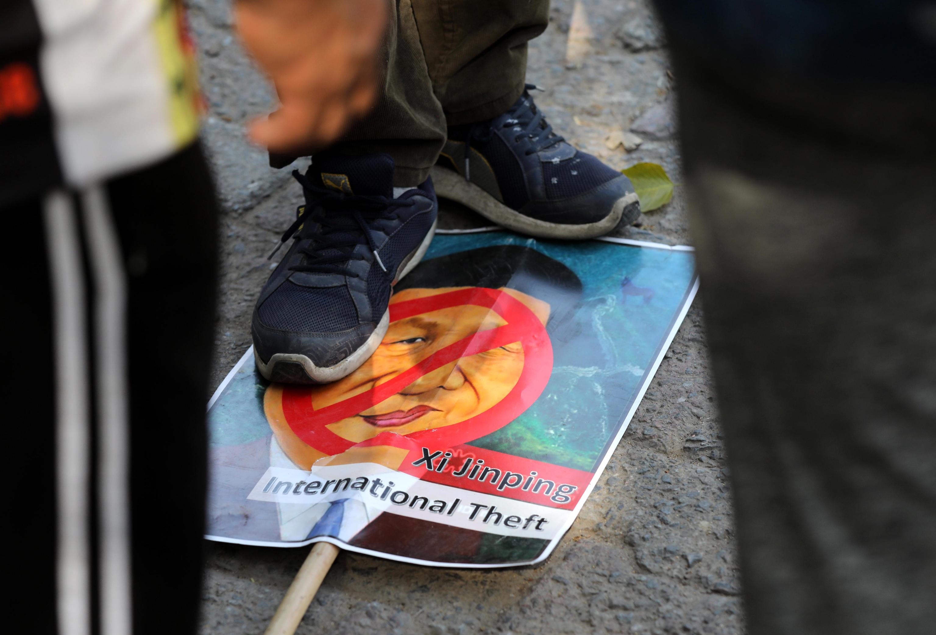 I protestanti calpestano l'immagine di Xi Jinping, che ha chiuso i confini tibetani I protestanti calpestano l'immagine di Xi Jinping, che ha chiuso i confini tibetani