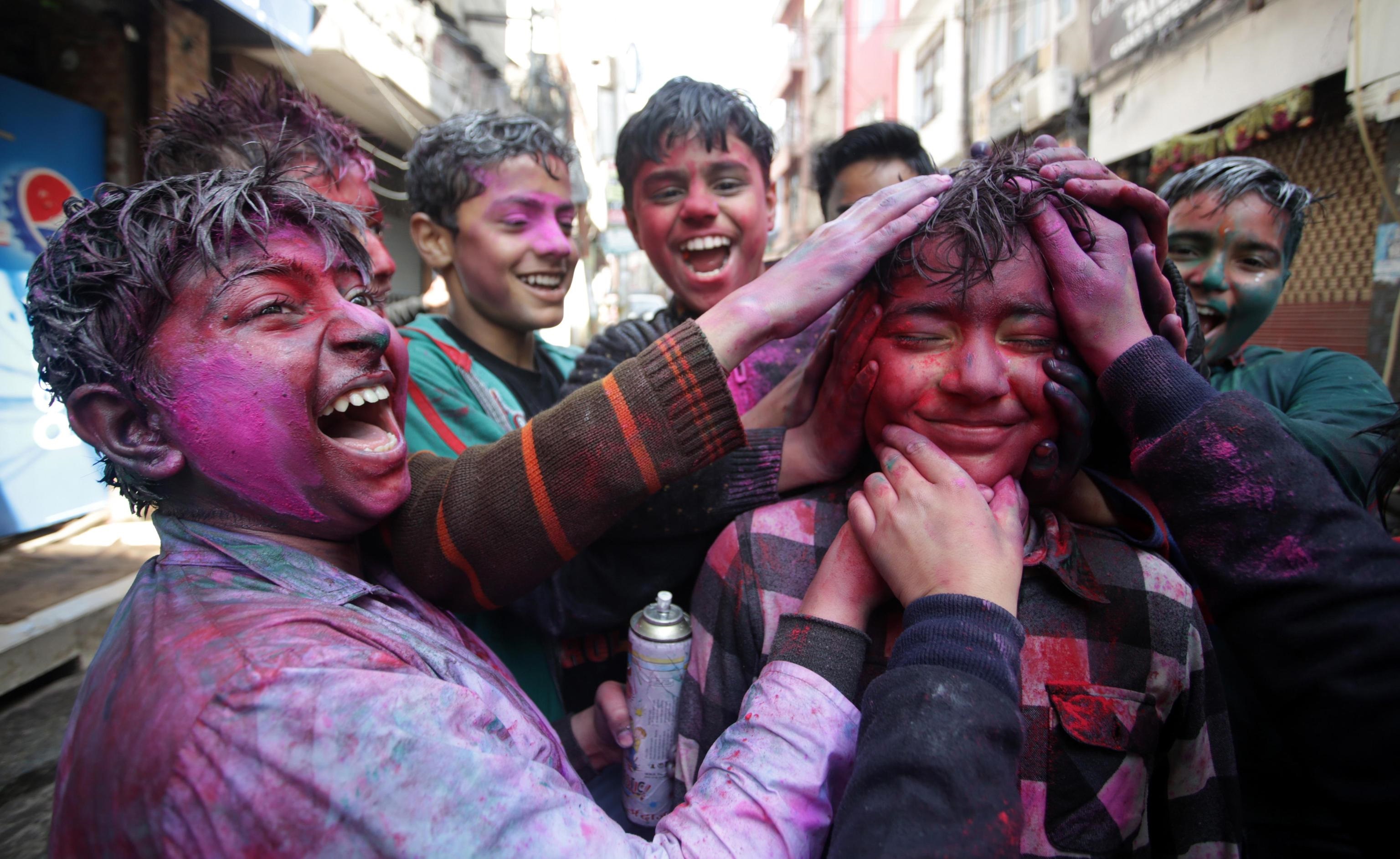 Alcuni ragazzi colorano il viso di un altro per festeggiare