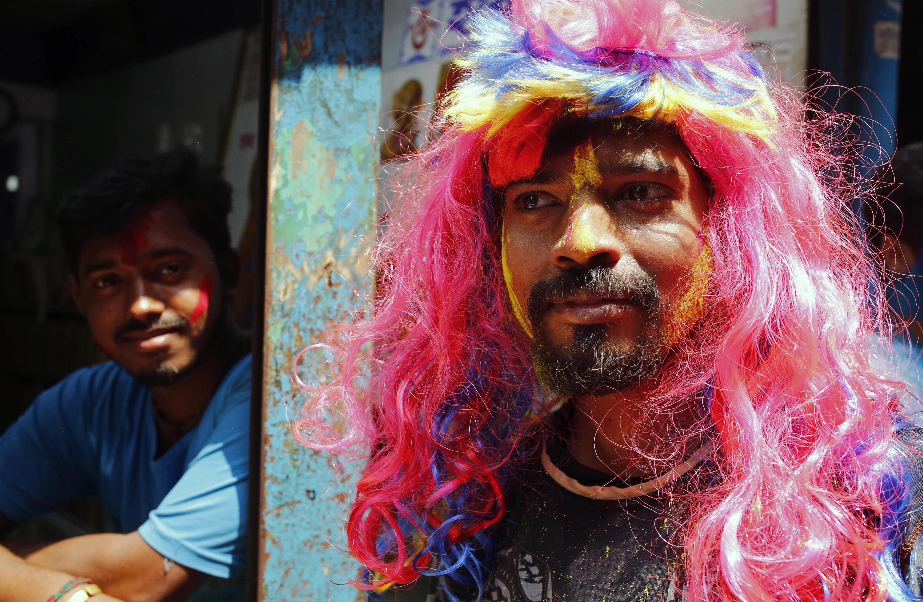 Un uomo con una parrucca a Dacca in occasione del Festival