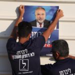 Attivisti appendono un poster del leader del partito politico Yisrael Beitenu