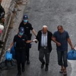 Alcuni agenti aiutano un uomo ad arrivare al pullman