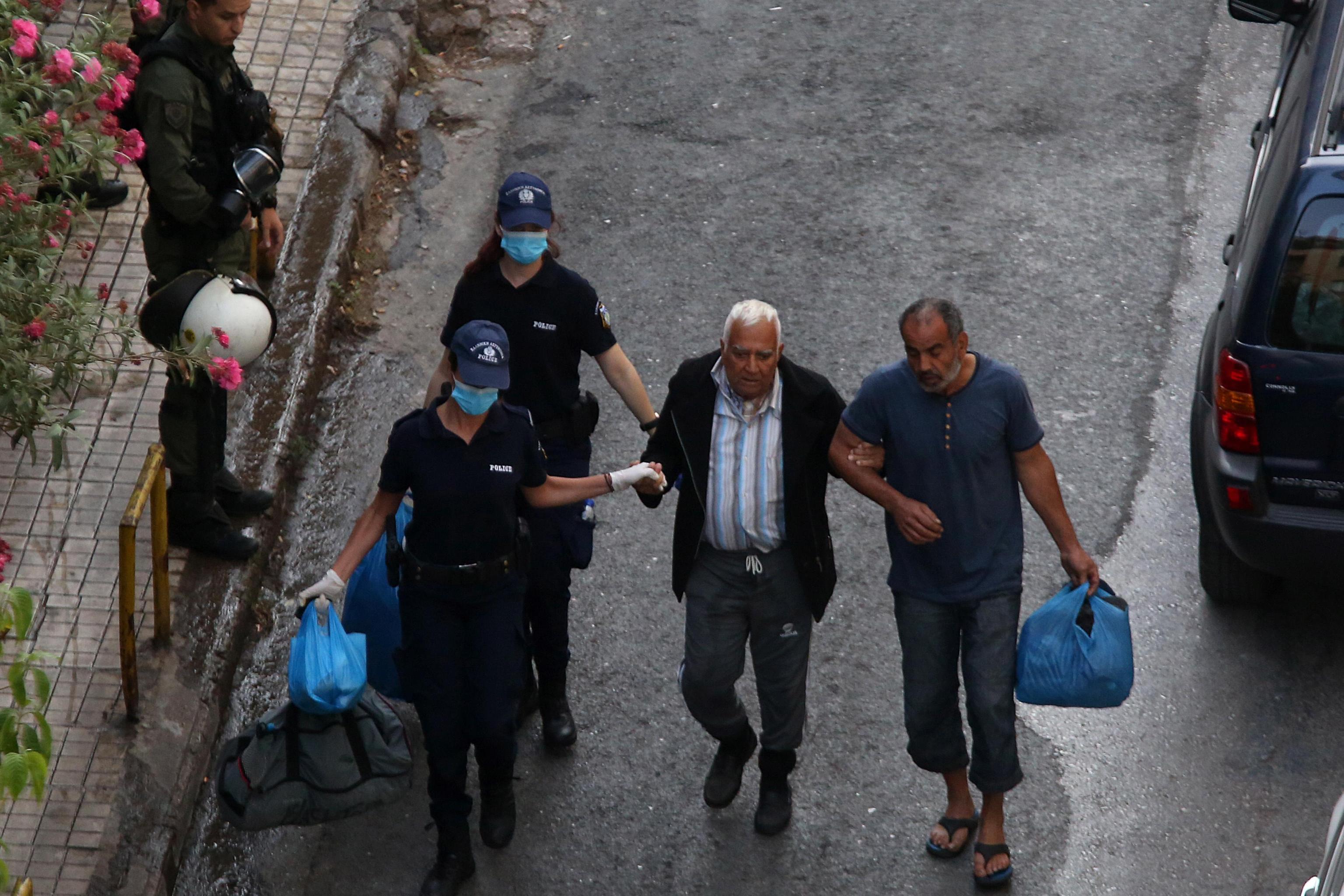 Alcuni agenti aiutano un uomo ad arrivare al pullman