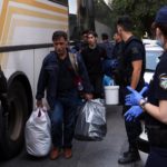 Un uomo porta via le sue cose in delle buste di plastica