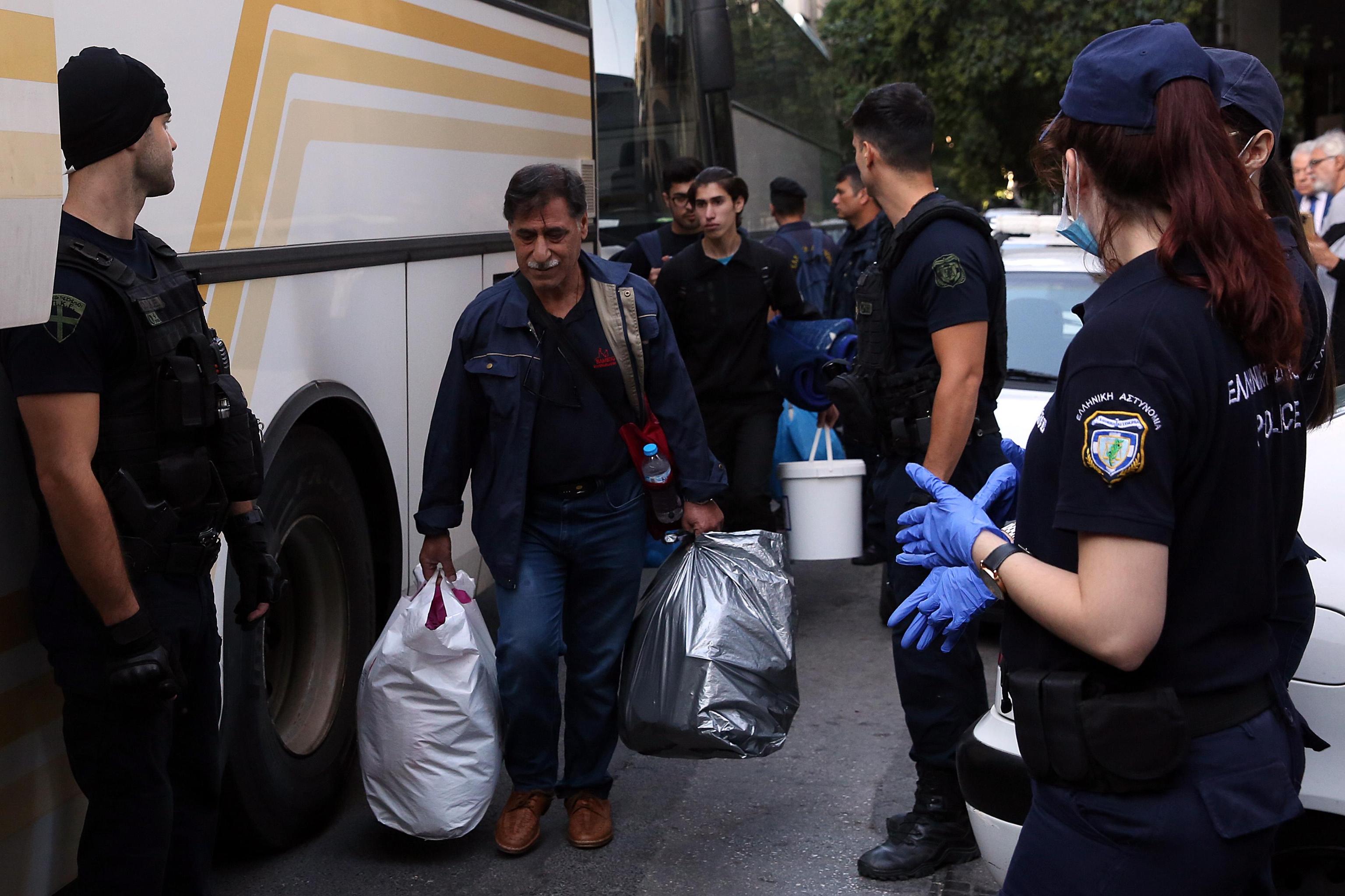 Un uomo porta via le sue cose in delle buste di plastica