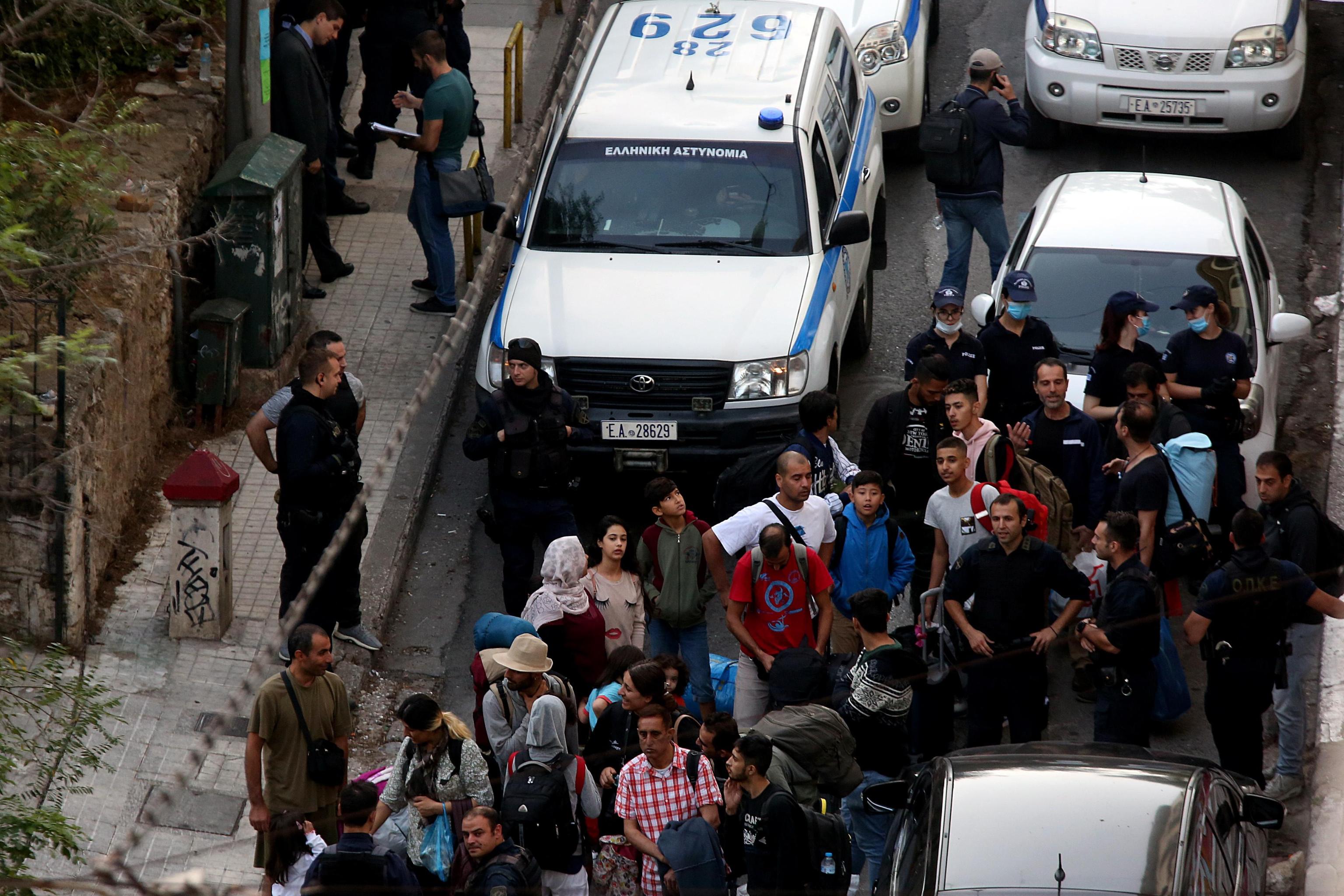 Gli agenti di polizia conducono i rifugiati sui pullman
