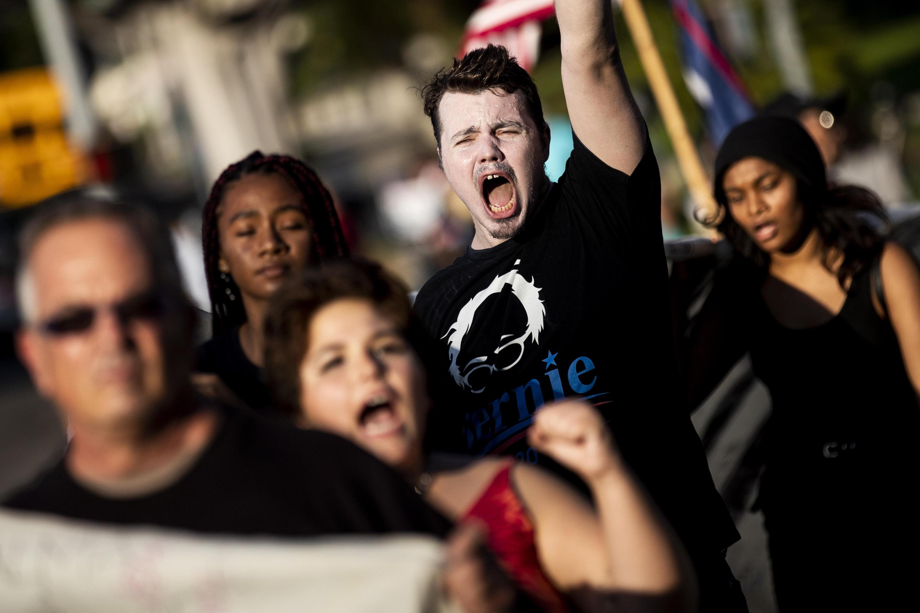 I manifestanti anti-Trump gridano mentre aspettano l'arrivo del presidente Donald Trump di fronte al Beverly Hills Hotel di Los Angeles