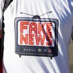 Un oppositore indossa una maglietta che fa un chiaro riferimento all'accusa spesso rivolta al presidente Trump, quella di diffondere "Fake News"