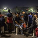 Alcuni cittadini cinesi attendono di assistere alla cerimonia di innalzamento della bandiera