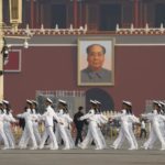 I veterani marciano in Piazza Tiananmen prima della cerimonia di deposizione della corona a Pechino, in Cina