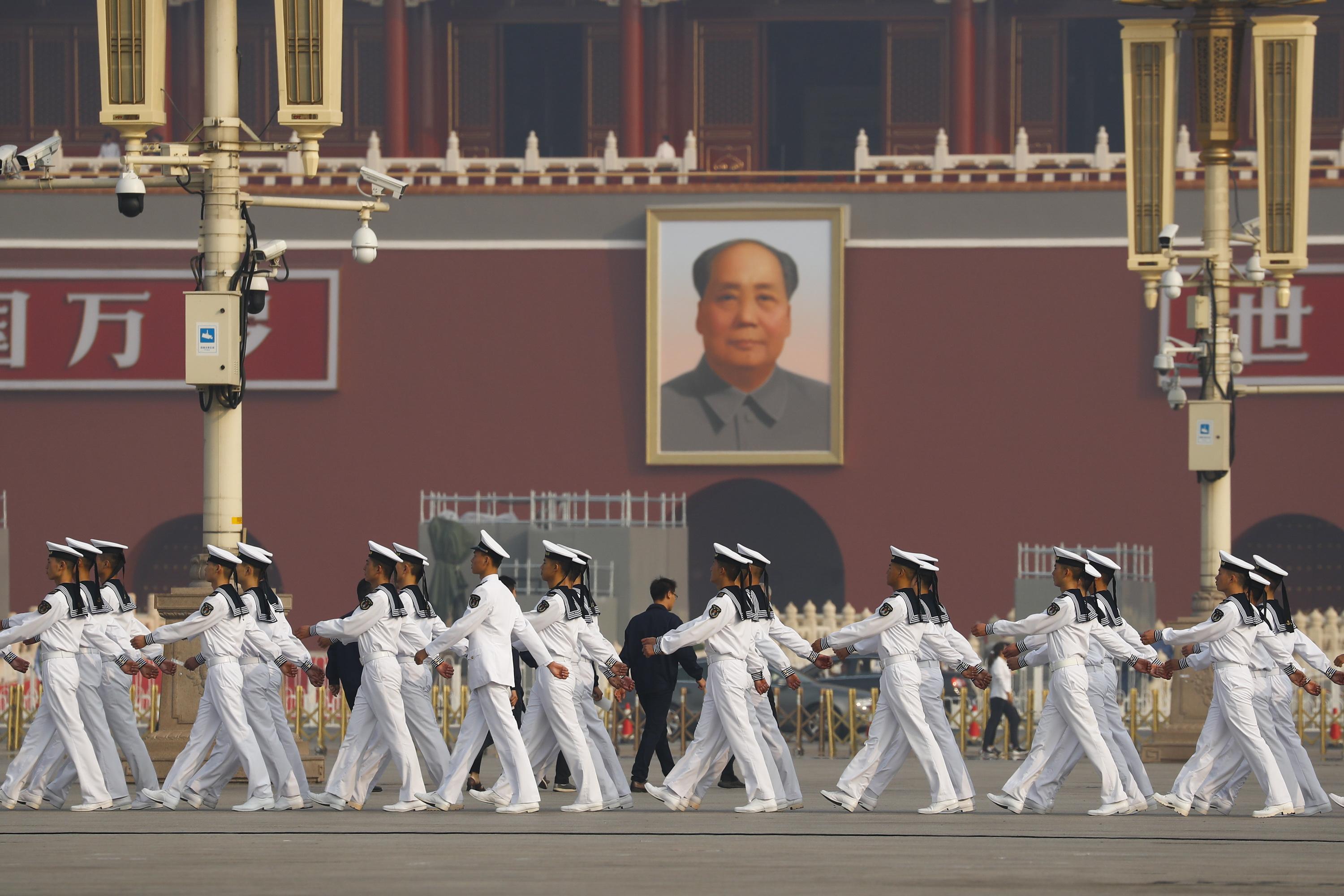 I veterani marciano in Piazza Tiananmen prima della cerimonia di deposizione della corona a Pechino, in Cina