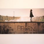 Una bambina cammina sopra a un muro