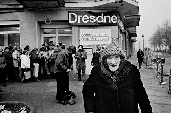 Berlino Ovest / Germania - 10 novembre 1989. Cittadini di Berlino Est in fila davanti a una banca per ritirare 100 dm che le Autorità di Berlino Ovest davano in regalo ai cittadini della DDR in occasione della loro prima visita all'Ovest. Generalmente il denaro veniva usato per acquistare generi alimentari o oggetti di uso comune introvabili all’Est. Foto di Livio Senigalliesi