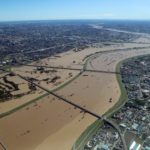 Un'immagine aerea fa vedere il fiume Arakawa straripante. Il corso d'acqua passa tra le prefetture di Tokyo e Saitama