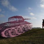 Persone camminano vicino alla scultura "Pink Tank Wrecked dell'artista ceco David Cerny