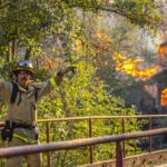 Un vigile del fuoco indica la strategia per domare le fiamme del rogo