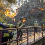 I vigili del fuoco cercano di spegnere le fiamme di un incendio che sembra indomabile