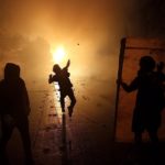 Un dimostrante lancia un oggetto durante le proteste in Cile del 28 ottobre contro il governo di Sebastian Pinera nelle strade di Santiago Un dimostrante lancia un oggetto durante le proteste in Cile del 28 ottobre contro il governo di Sebastian Pinera nelle strade di Santiago