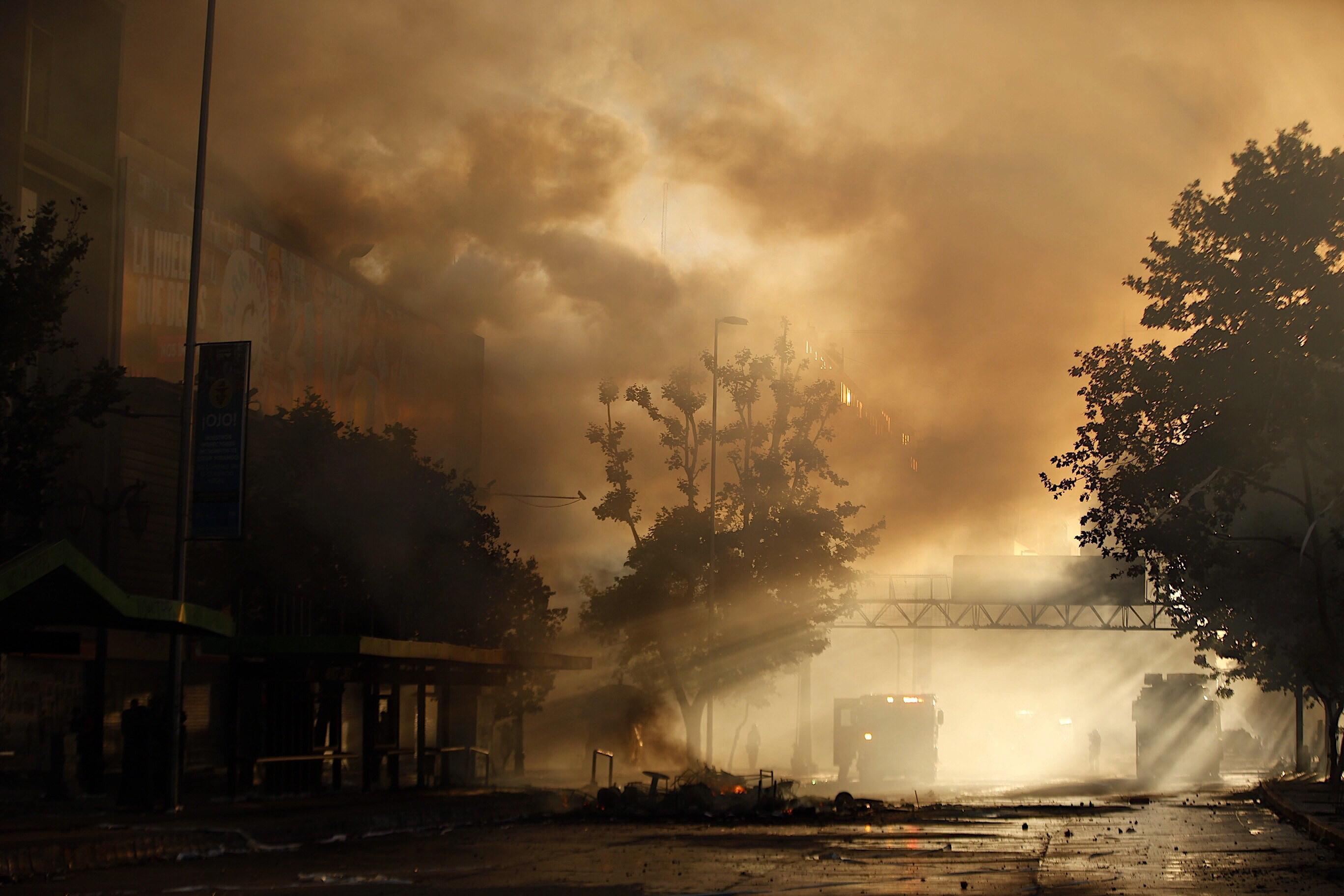 I pompieri cercano di spegnere le fiamme appiccate dai manifestanti durante le proteste I pompieri cercano di spegnere le fiamme appiccate dai manifestanti durante le proteste