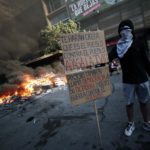 "Ti faranno credere che è il popolo contro il popolo. Spegni la televisione", è scritto nel cartello mostrato dal manifestante "Ti faranno credere che è il popolo contro il popolo. Spegni la televisione", è scritto nel cartello mostrato dal manifestante