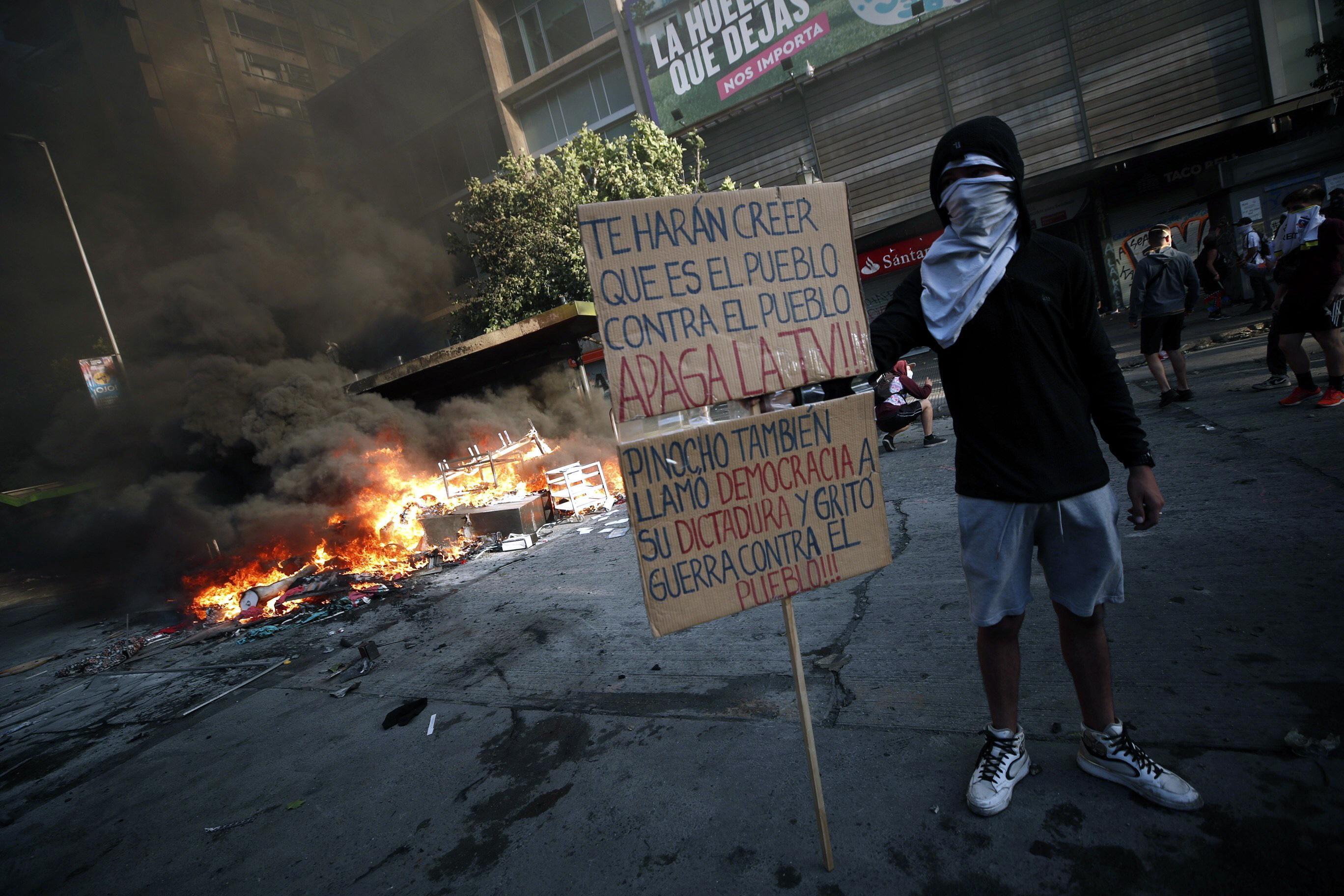 "Ti faranno credere che è il popolo contro il popolo. Spegni la televisione", è scritto nel cartello mostrato dal manifestante "Ti faranno credere che è il popolo contro il popolo. Spegni la televisione", è scritto nel cartello mostrato dal manifestante