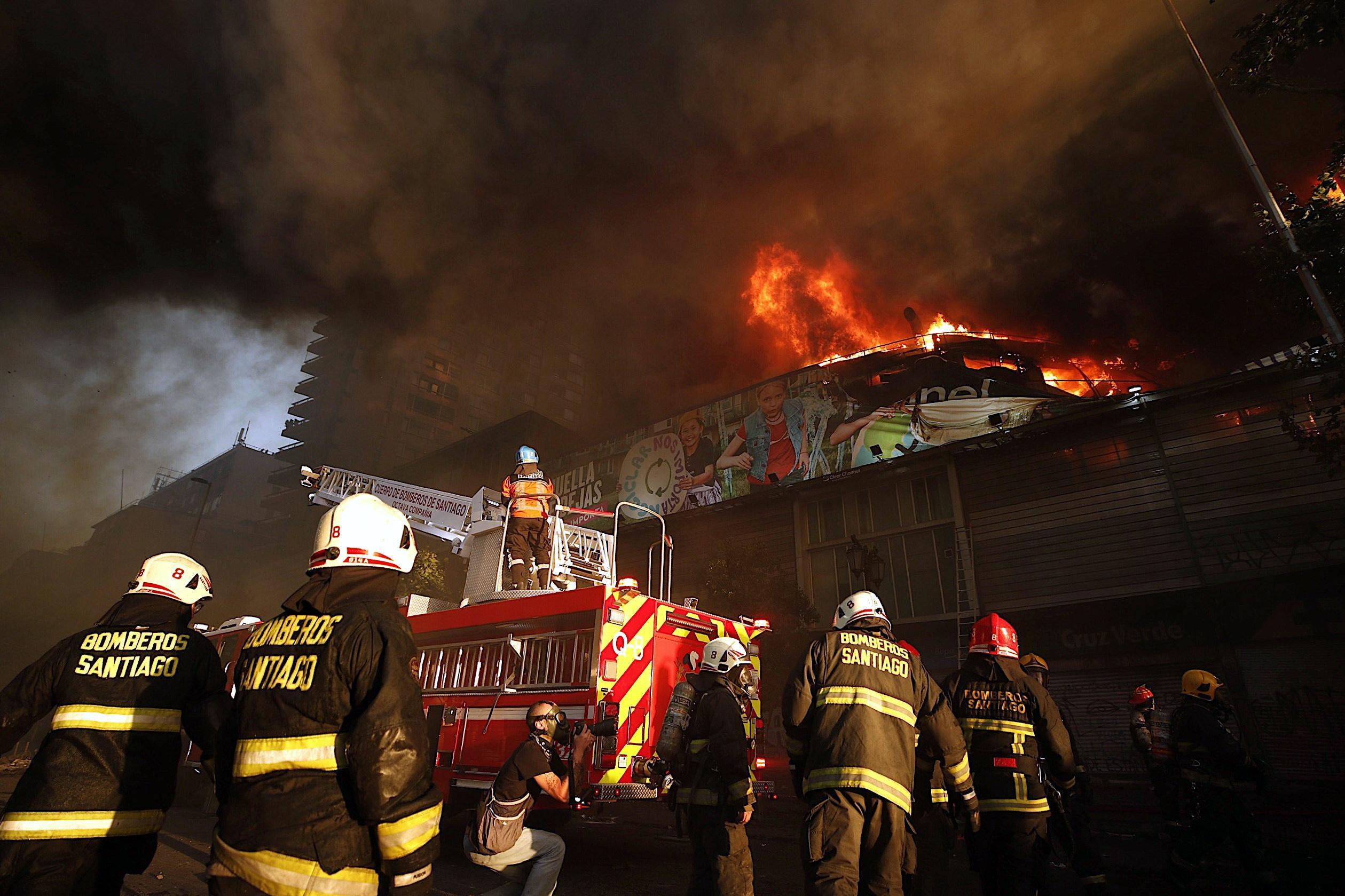 I pompieri domano uno dei numerosi incendi appiccati a Santiago I pompieri domano uno dei numerosi incendi appiccati a Santiago