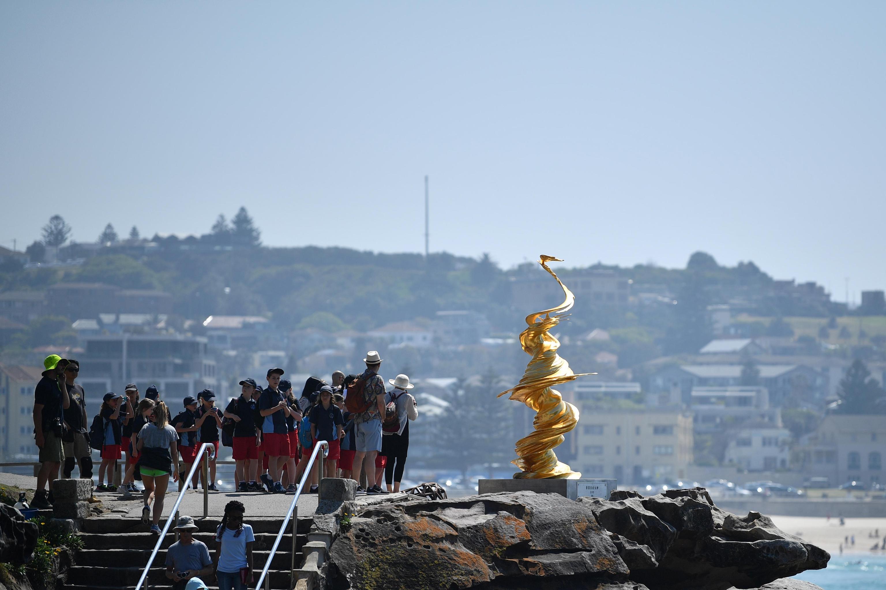 Visitatori si riuniscono attorno alla scultura 'Mad Liberty' dell'artista cinese Wang Kiafang
