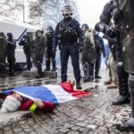 Una manifestante stesa a terra di fronte alla polizia il 24 novembre 2018 Una manifestante stesa a terra di fronte alla polizia il 24 novembre 2018