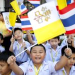 Bambini in festa accolgono il Santo Padre sventolando bandiere del Vaticano e della Thailandia