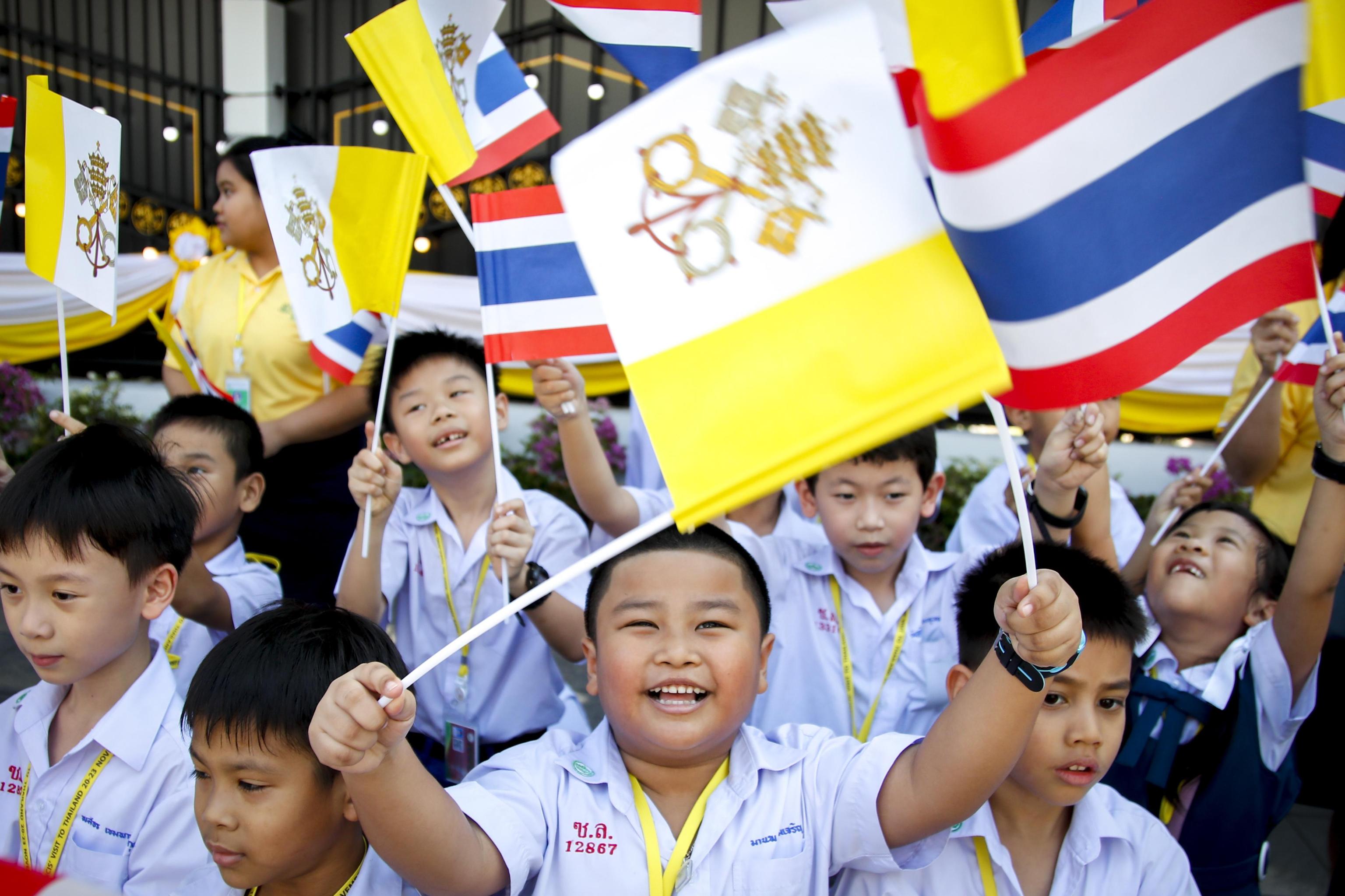 Bambini in festa accolgono il Santo Padre sventolando bandiere del Vaticano e della Thailandia