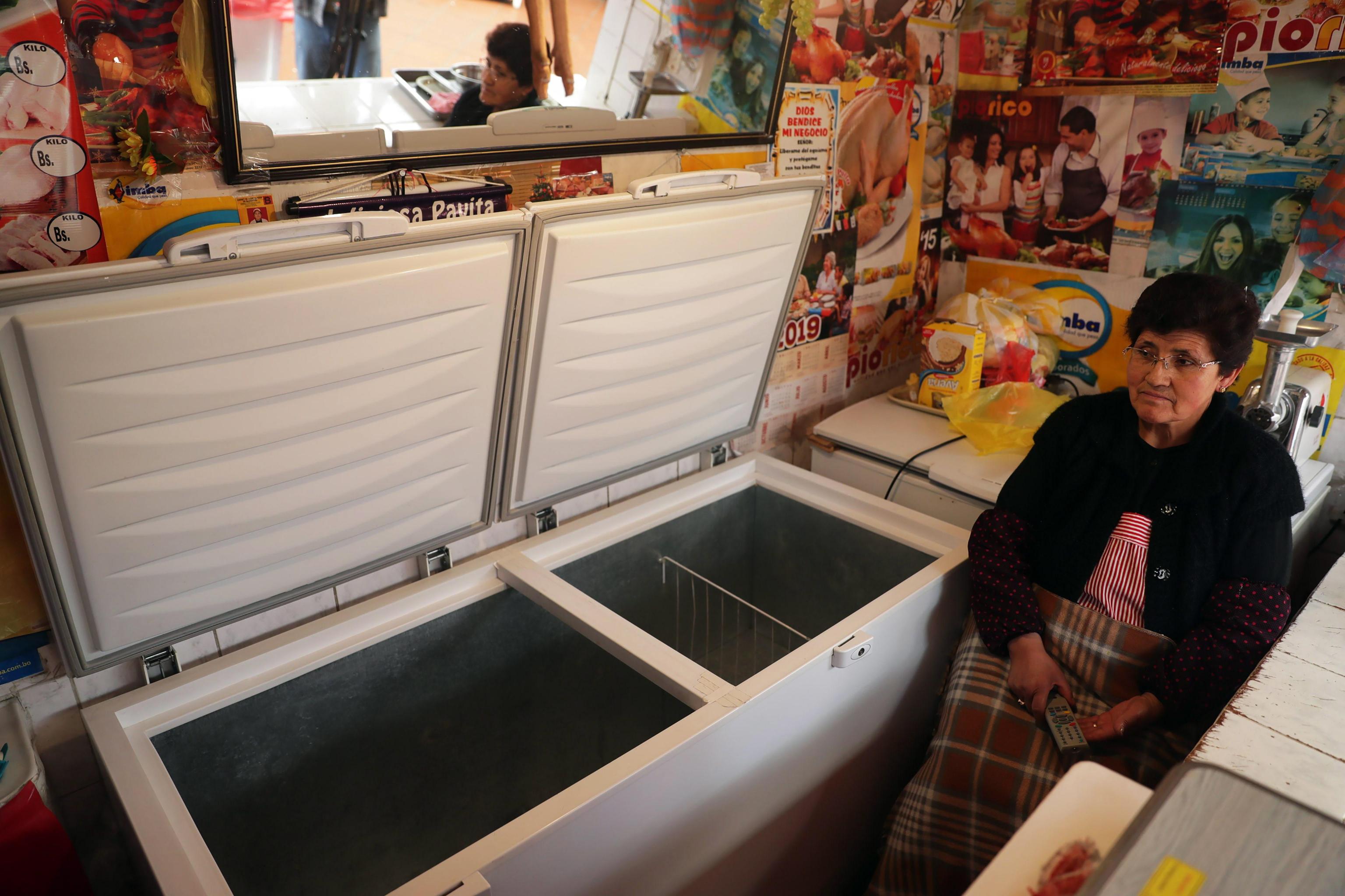 La Paz, una donna mostra i freezer vuoti nel suo negozio a causa delle manifestazioni