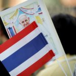 Un bandierina Thai sventola accanto ad una raffigurazione del Santo Padre