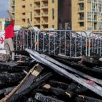 Un manifestante sopra i detriti alza il pugno Un manifestante sopra i detriti alza il pugno