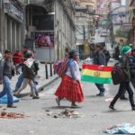 Cittadini boliviani si dirigono a Murillo Square, a La Paz. A terra numerosi detriti dovuti alle recenti proteste che hanno portato alle dimissioni e al trasferimento in Messico dell'ex Presidente Evo Morales. In queste ore la polizia boliviana sta assumendo il controllo delle strade delle principali città del Paese