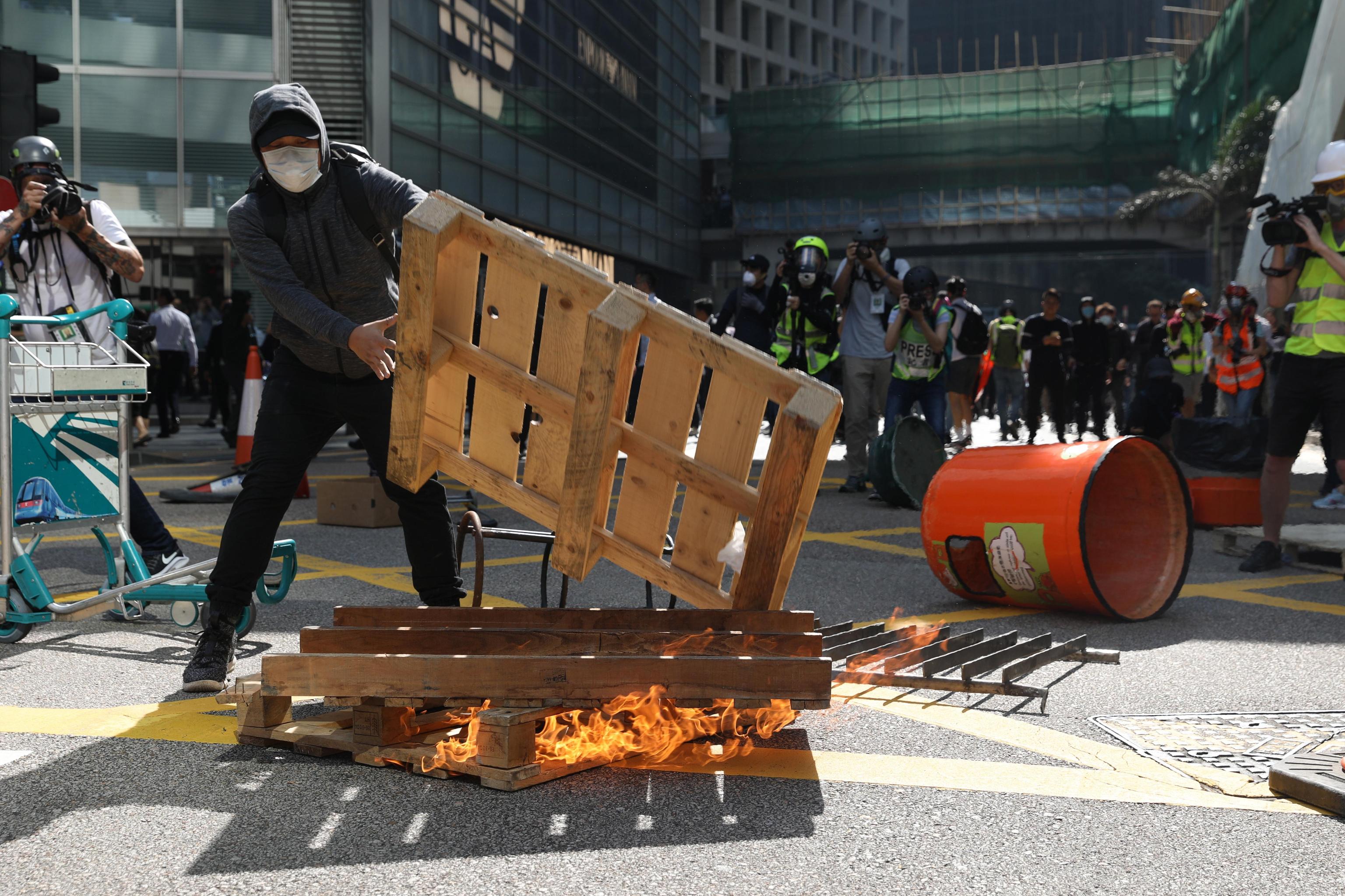 I manifestanti costruiscono cataste e barriere per le strade di Hong Kong e poi le danno alle fiamme