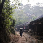 Un membro della tribù cammina tra le abitazioni del villaggio Kanekes