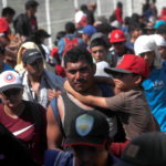 Un uomo e un bambino, a pochi passi dal confine messicano: sono tra le migliaia di persone che compongono la carovana