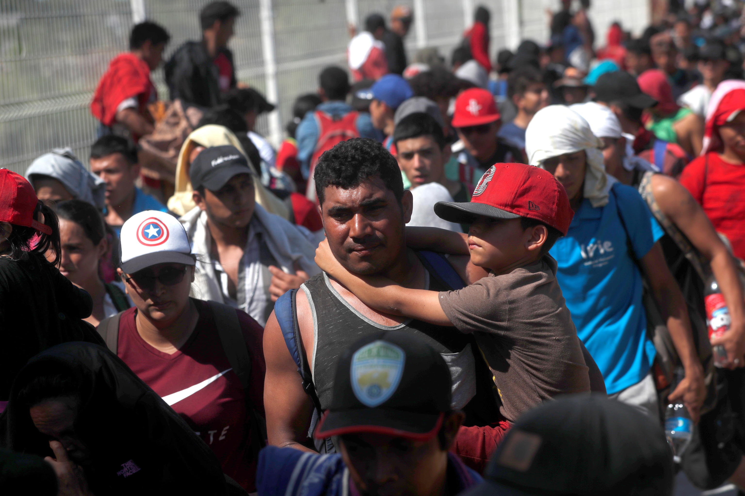 Un uomo e un bambino, a pochi passi dal confine messicano: sono tra le migliaia di persone che compongono la carovana