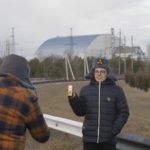 Le foto davanti alla nuova copertura del reattore 4 della centrale. In mano - come sempre - un contatore geiger Le foto davanti alla nuova copertura del reattore 4 della centrale. In mano - come sempre - un contatore geiger