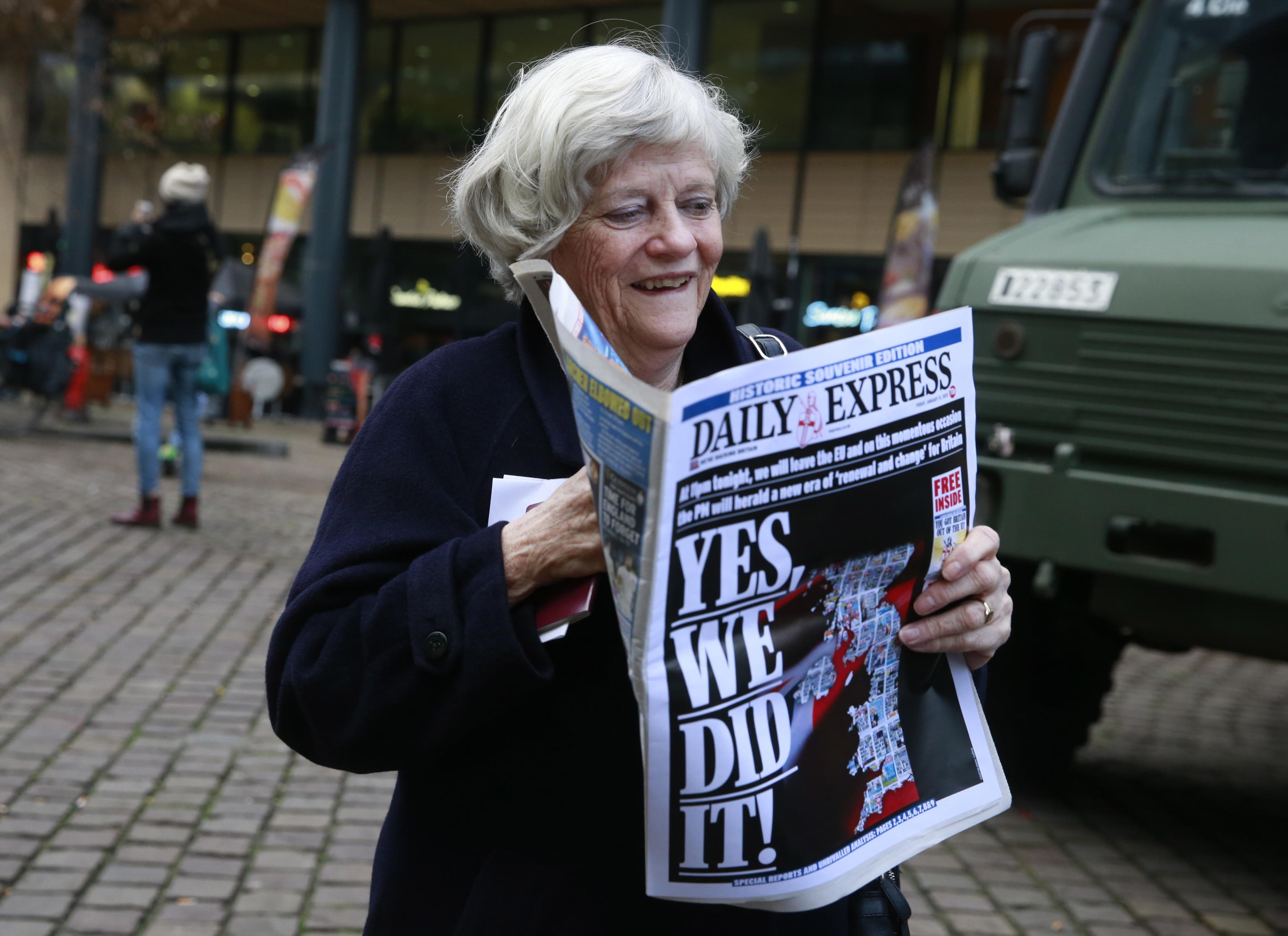 Ann Widdecombe con un giornale davanti alla stazione ferroviaria