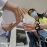 Una studentessa si lava le mani prima di iniziare le lezioni in una scuola superiore a Phnom Penh, in Cambogia