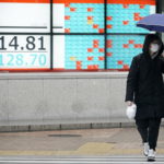 Una coppia di giapponesi che passeggia per Tokyo con le maschere antivirus