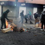 Cittadini in rivolta danno fuoco a casse di legno e altri oggetti