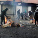 Cittadini in rivolta danno fuoco a casse di legno e altri oggetti Cittadini in rivolta danno fuoco a casse di legno e altri oggetti