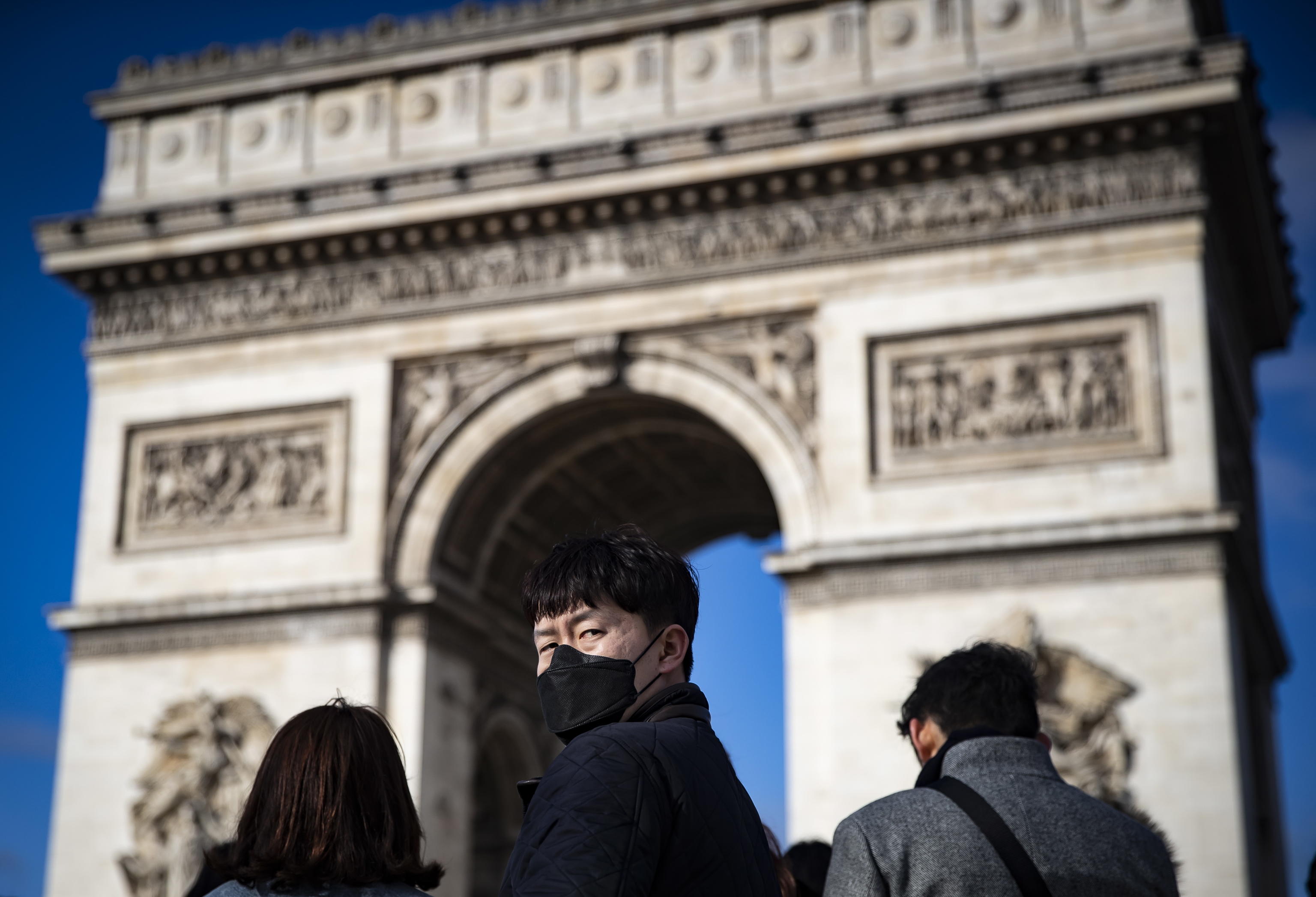 A Parigi i turisti sugli Champs Elysees indossano le tipiche mascherine