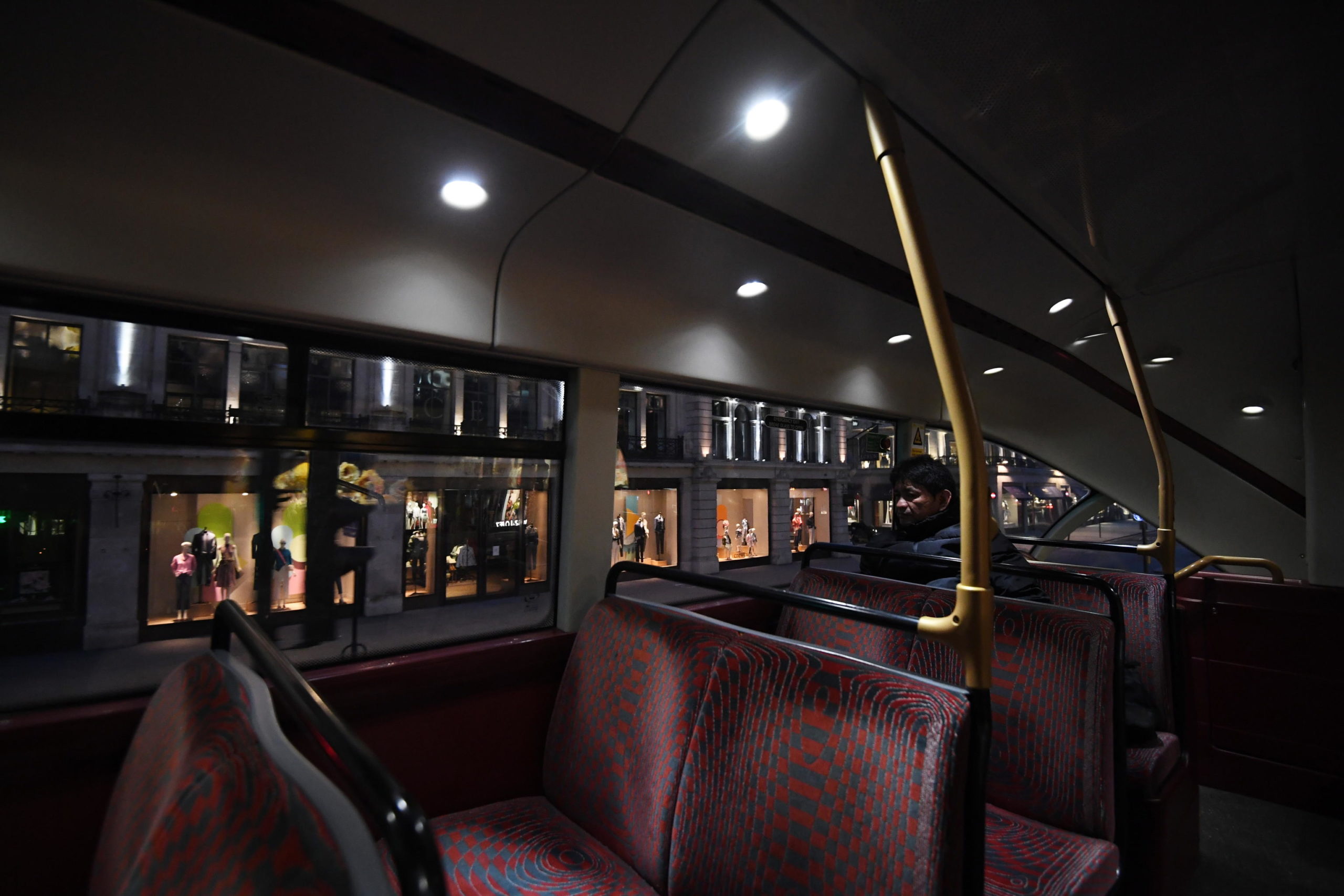 Un uomo seduto su un autobus quasi vuoto che attraversa Regent street a Londra