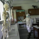 Indonesia: la Croce Rossa disinfetta un'aula di una scuola di Jakarta. Il governo ha disposto la chiusura delle scuole per due settimane a partire da oggi. Nel paese, 117 contagiati e cinque morti.