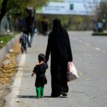 Una mamma e il suo bambino percorrono a piedi la strada verso casa Una mamma e il suo bambino percorrono a piedi la strada verso casa